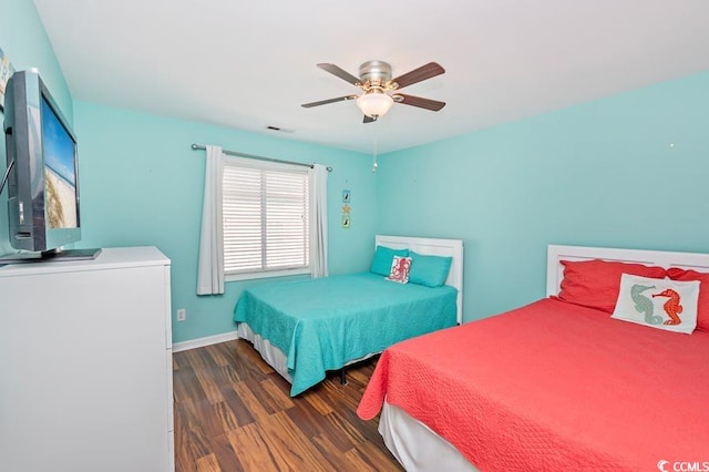 bedroom featuring visible vents, wood finished floors, a ceiling fan, and baseboards