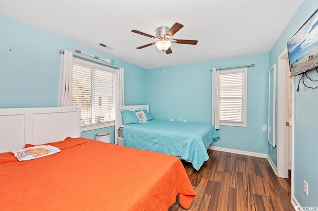 bedroom featuring visible vents, ceiling fan, baseboards, and wood finished floors