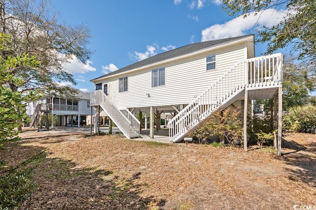 back of property with stairs and a patio