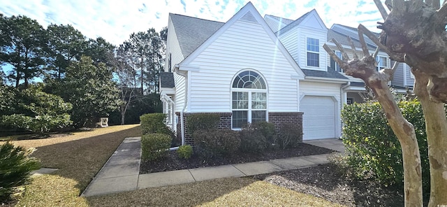 view of front of home featuring brick siding and roof with shingles