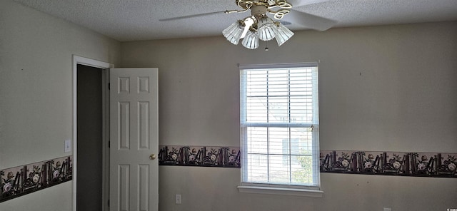 interior details featuring a textured ceiling and a ceiling fan