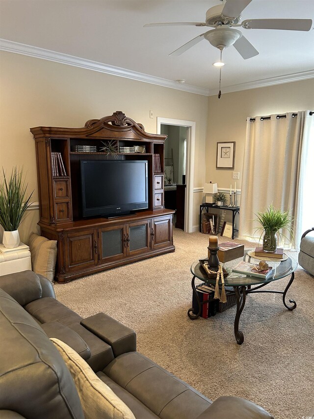 living area featuring carpet floors, ornamental molding, and a ceiling fan