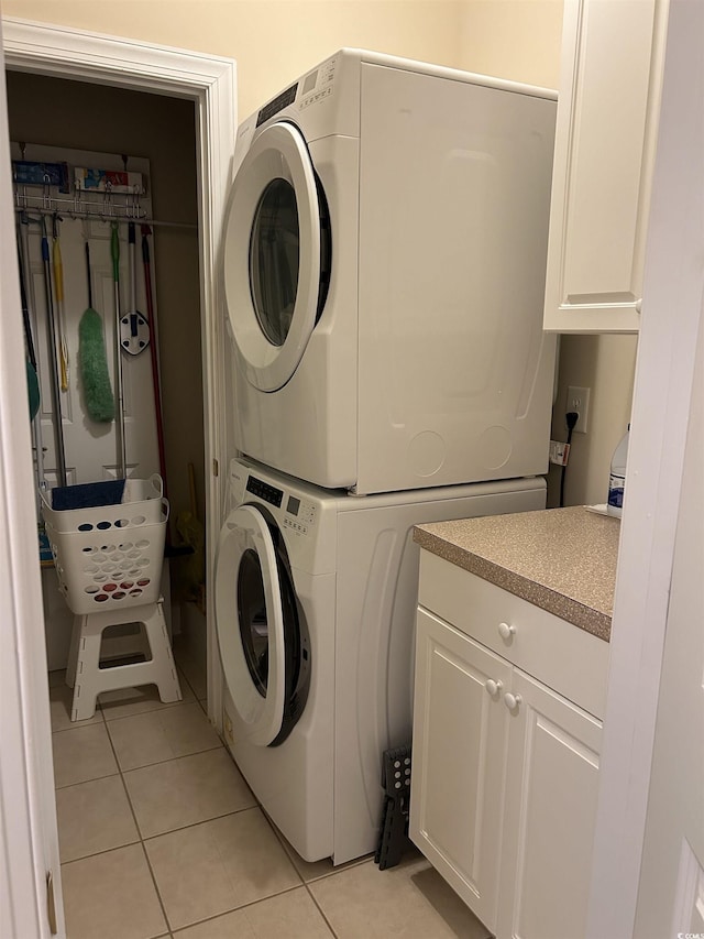 washroom featuring light tile patterned floors, laundry area, and stacked washer / drying machine