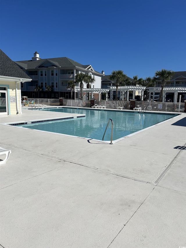 community pool featuring a patio and fence