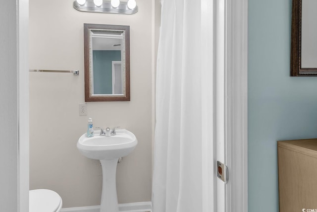 bathroom featuring toilet and baseboards