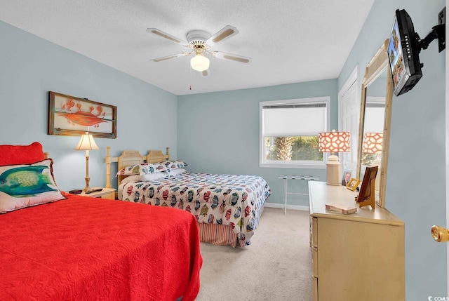 bedroom featuring light carpet, ceiling fan, a textured ceiling, and baseboards