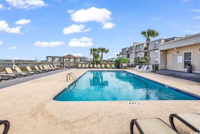 pool with a patio and fence