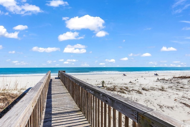 view of home's community featuring a water view and a beach view