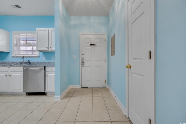 kitchen featuring white cabinets, dishwasher, visible vents, and light tile patterned floors