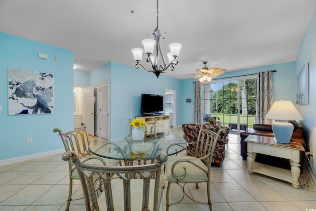 dining area with ceiling fan with notable chandelier, light tile patterned flooring, and baseboards