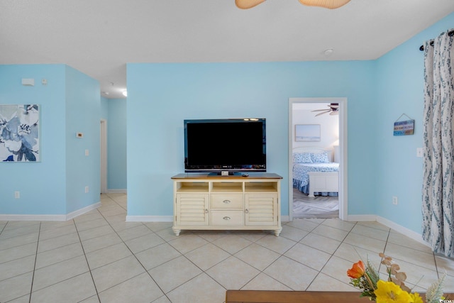 unfurnished living room featuring a ceiling fan, baseboards, and light tile patterned floors