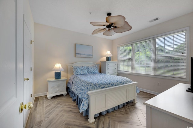 bedroom with a ceiling fan, visible vents, and baseboards