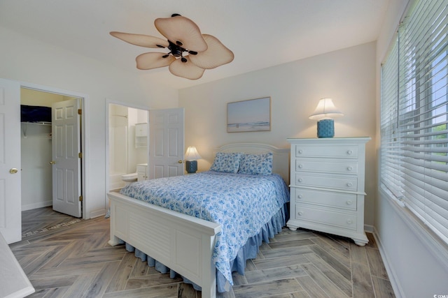 bedroom featuring connected bathroom, a ceiling fan, baseboards, a spacious closet, and a closet