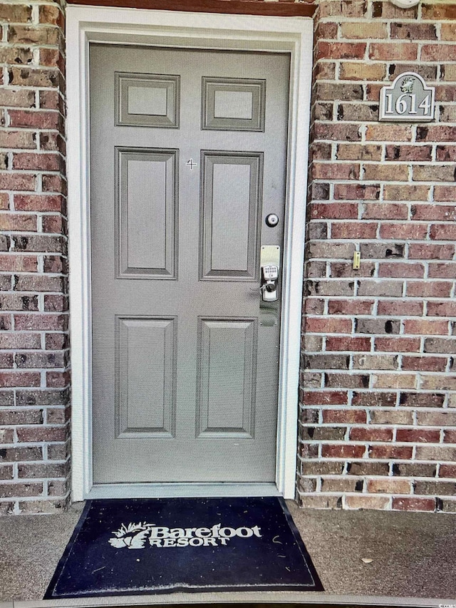 view of exterior entry featuring brick siding