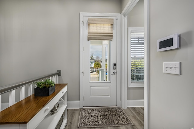 doorway to outside with wood finished floors and baseboards