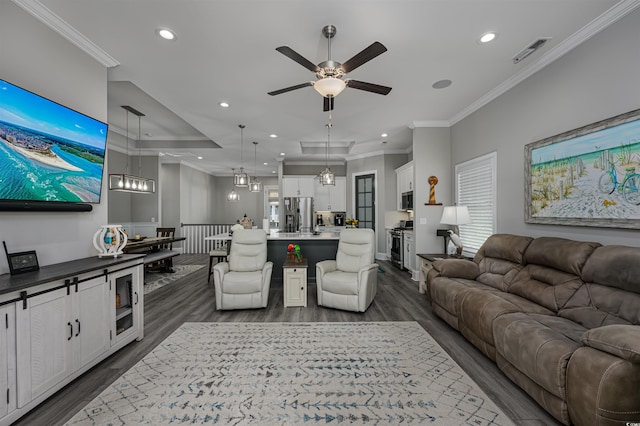 living area with dark wood-style floors, recessed lighting, visible vents, and ornamental molding