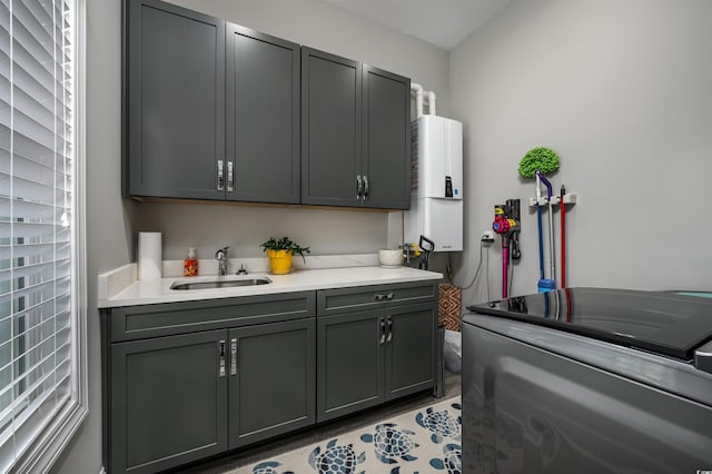 interior space with cabinet space, washing machine and dryer, water heater, and a sink