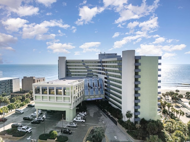 view of property with uncovered parking and a water view