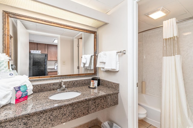 bathroom featuring toilet, shower / bath combo, a sink, and tile patterned flooring