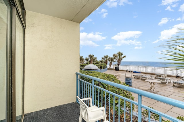 balcony featuring a water view and a beach view