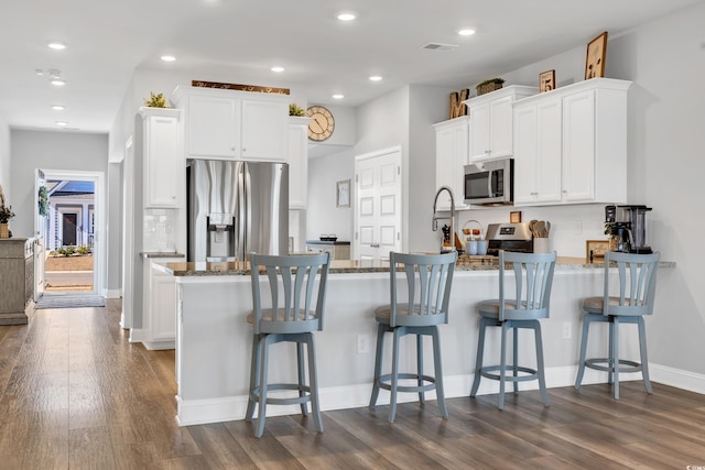 738 Harrison Mill St, Myrtle Beach, SC 29579 - kitchen featuring appliances with stainless steel finishes, a peninsula, dark wood-style floors, stone countertops, and recessed lighting