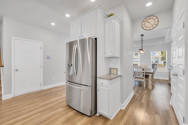 kitchen with stainless steel refrigerator with ice dispenser, light wood finished floors, recessed lighting, white cabinetry, and baseboards