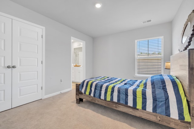 bedroom with carpet, visible vents, connected bathroom, and baseboards