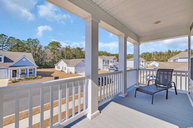 wooden terrace with a residential view and a porch