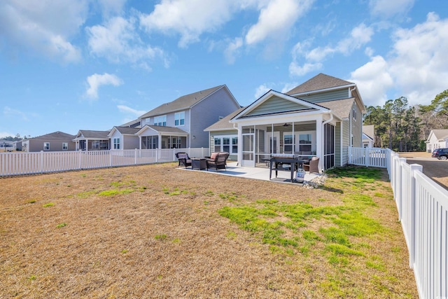 rear view of property featuring a ceiling fan, a sunroom, a fenced backyard, a yard, and a patio area