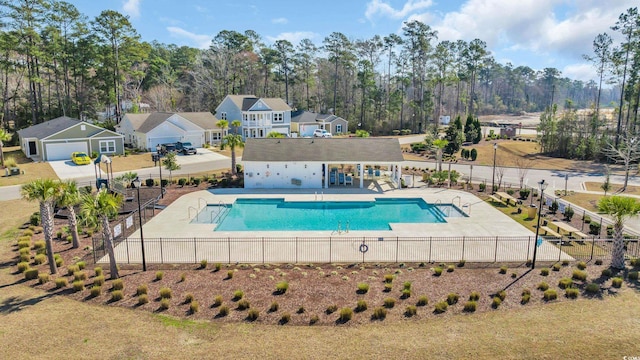 community pool featuring a patio, fence, and a residential view