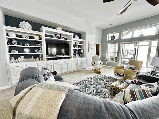 living area featuring a ceiling fan, light colored carpet, visible vents, and baseboards