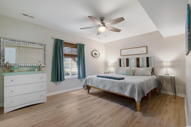 bedroom with a ceiling fan, baseboards, visible vents, and light wood finished floors