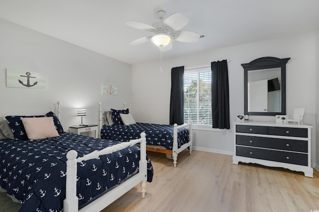 bedroom featuring ceiling fan, baseboards, and wood finished floors