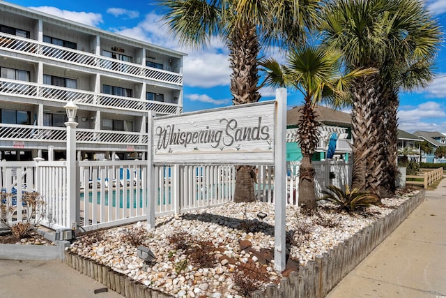 view of building exterior featuring a community pool and fence