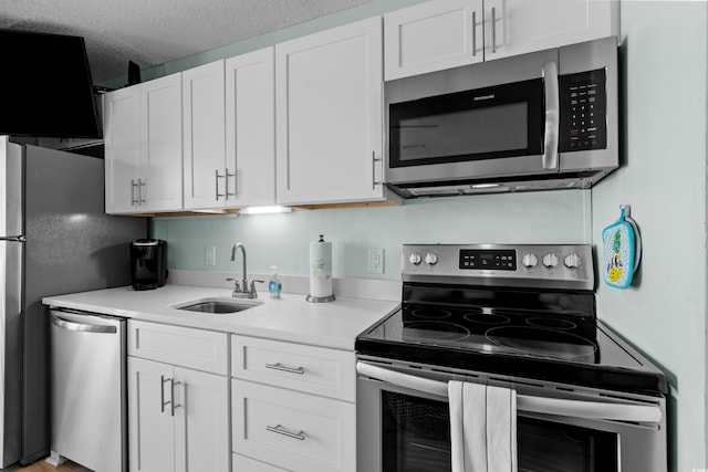 kitchen with a sink, light countertops, white cabinets, and stainless steel appliances