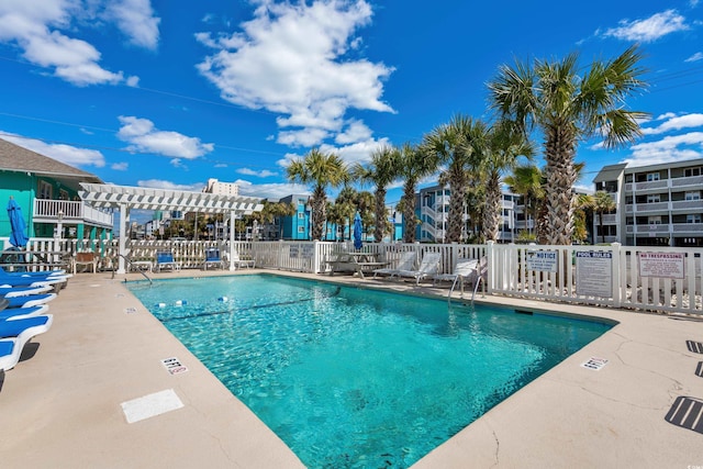 pool featuring a patio, fence, and a pergola