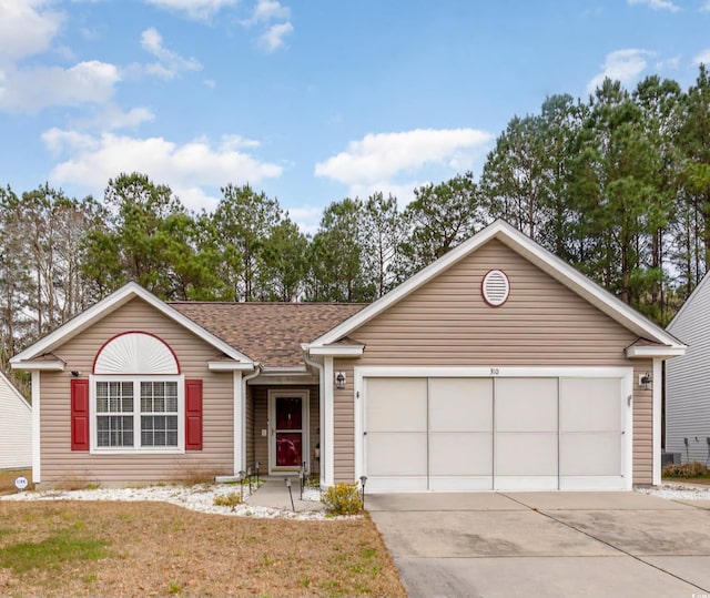 ranch-style home with a garage, a front yard, roof with shingles, and driveway