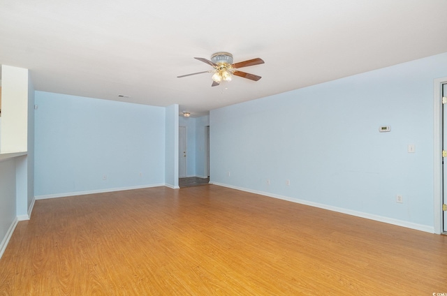 empty room featuring light wood-style floors, visible vents, ceiling fan, and baseboards