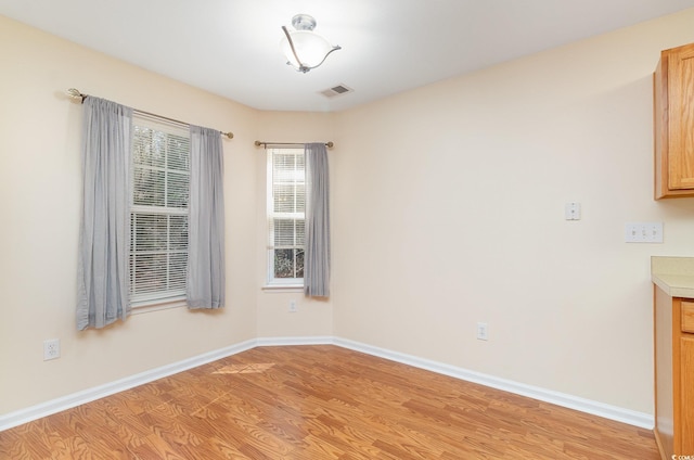 interior space featuring light wood-type flooring, visible vents, and baseboards