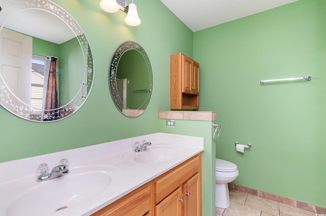 full bath with double vanity, tile patterned flooring, a sink, and toilet