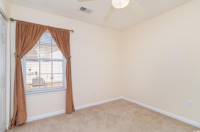 unfurnished room featuring a ceiling fan, visible vents, light carpet, and baseboards