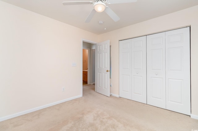 unfurnished bedroom featuring light carpet, ceiling fan, a closet, and baseboards