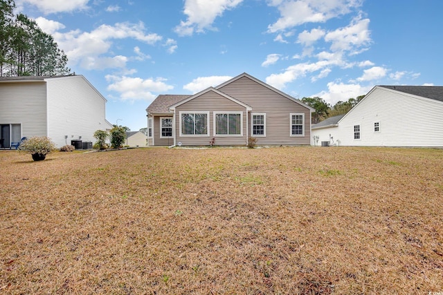 back of property with a lawn and central air condition unit