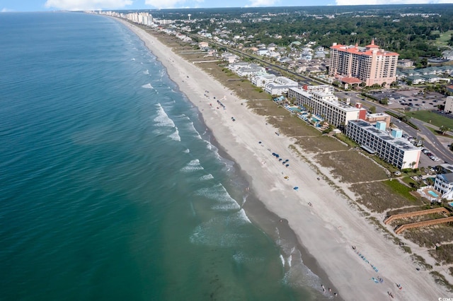 drone / aerial view featuring a water view, a view of city, and a beach view