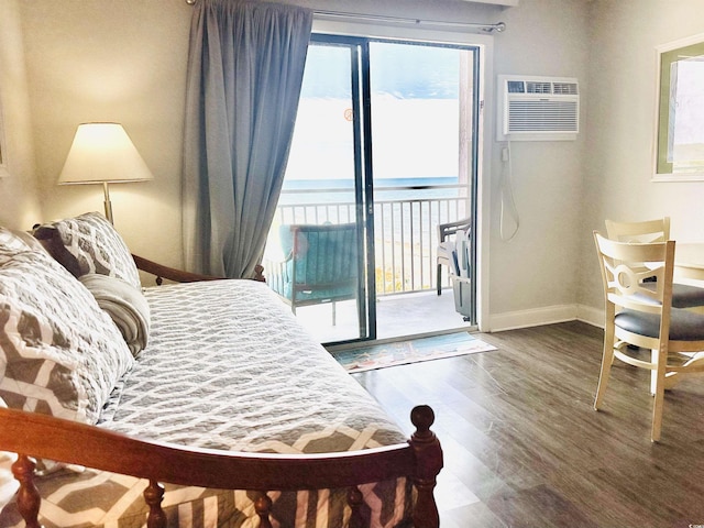 bedroom featuring baseboards, an AC wall unit, wood finished floors, and access to outside