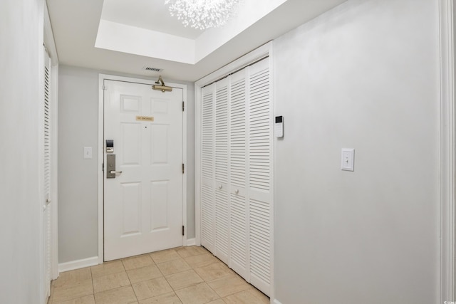 entryway with light tile patterned flooring, baseboards, and visible vents