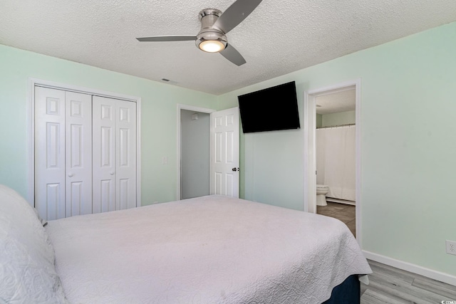 bedroom with ceiling fan, a textured ceiling, a closet, and wood finished floors