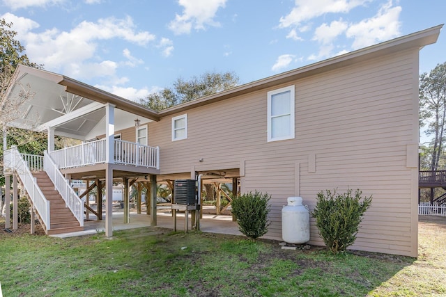 back of property with a patio area, a lawn, and stairway