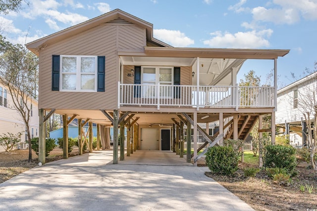 view of front of house featuring a carport, covered porch, concrete driveway, and stairs