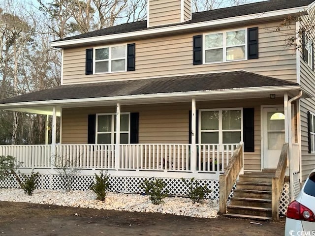 view of front of house with covered porch, a shingled roof, and a chimney